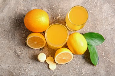 C vitamini tableti, suda çözünmüş ve meyveler gri grunge masasında.