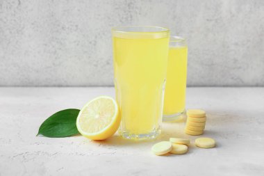 C vitamini tableti. Beyaz grunge masasında suda ve limonda çözünmüş.