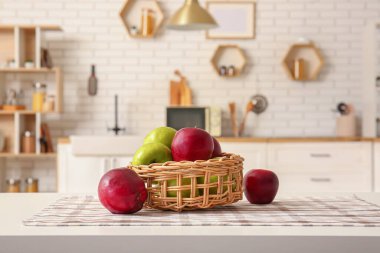 Modern mutfağın içindeki masada elmalı sepet.