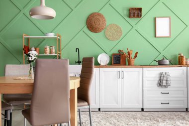 Masasında beyaz tezgah ve vazo olan modern mutfağın içi.