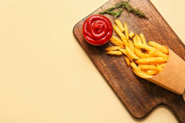 Tahta tahta tahta tahta ve lezzetli patates kızartması, biberiye ve ketçap renkli arka plan.