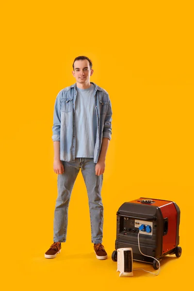 Young Man Portable Gasoline Generator Electric Fan Heater Yellow Background — Foto Stock