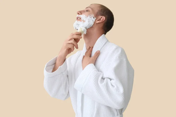 Junger Mann Trägt Rasierschaum Auf Gesicht Vor Beigem Hintergrund Auf — Stockfoto