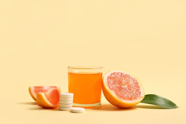 stock image Glass of vitamin C effervescent tablet dissolved in water and grapefruit on beige background