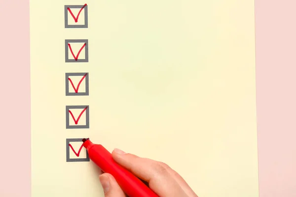 Woman marking on checklist box with red marker
