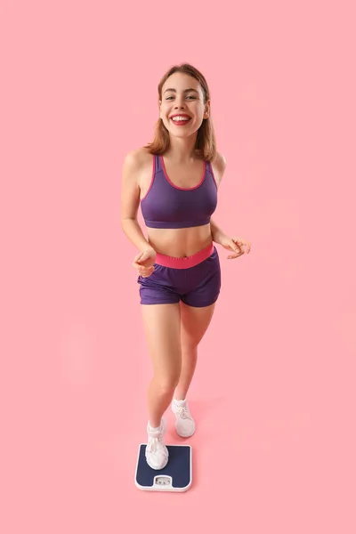 Спортивная Молодая Женщина Измеряет Свой Вес Весах Розовом Фоне — стоковое фото