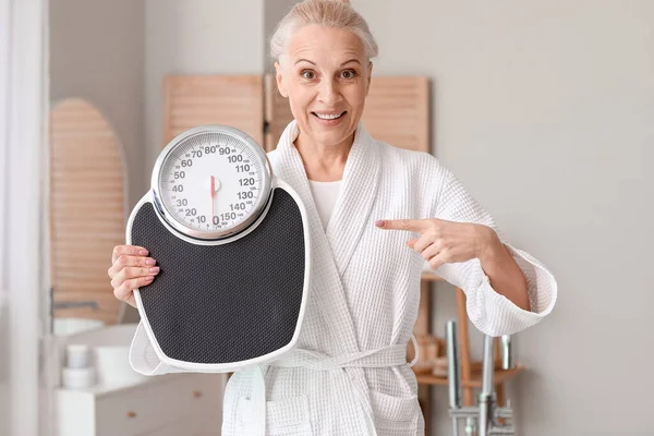 Mature Woman Pointing Scales Bathroom — Stock Photo, Image