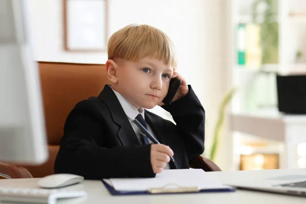 オフィスのテーブルで携帯電話で話している面白い小さなビジネスマン — ストック写真