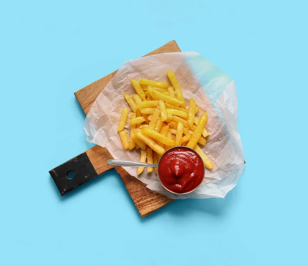 木板配上美味的法式薯条和彩色背景番茄酱 — 图库照片