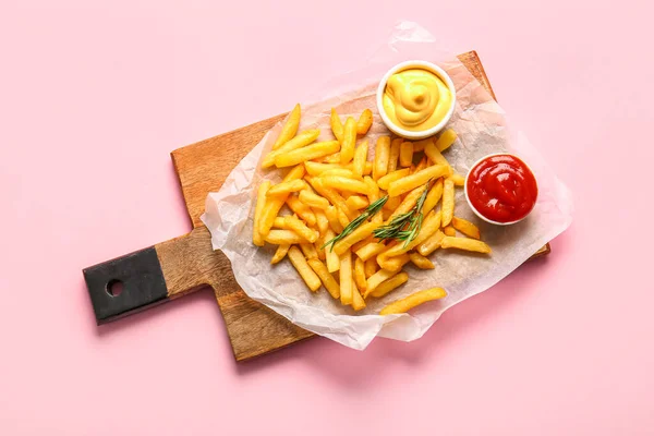 木木板配上美味的法式薯条 迷迭香和粉红色背景的酱汁 — 图库照片