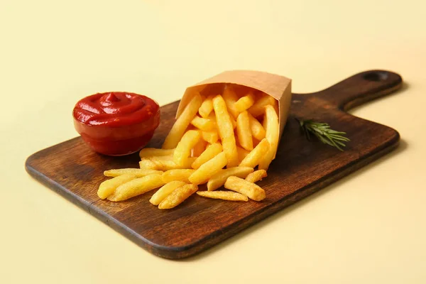 木制木板 纸盒上有美味的法式薯条和彩色背景番茄酱 — 图库照片