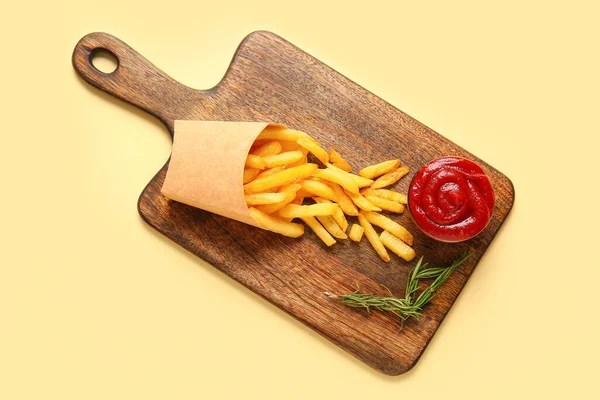 木制木板 用纸盒装着美味的法式薯条 迷迭香和番茄酱 以色彩为背景 — 图库照片
