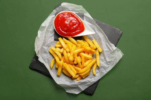 Skida Ombord Läckra Pommes Frites Och Ketchup Grön Bakgrund — Stockfoto