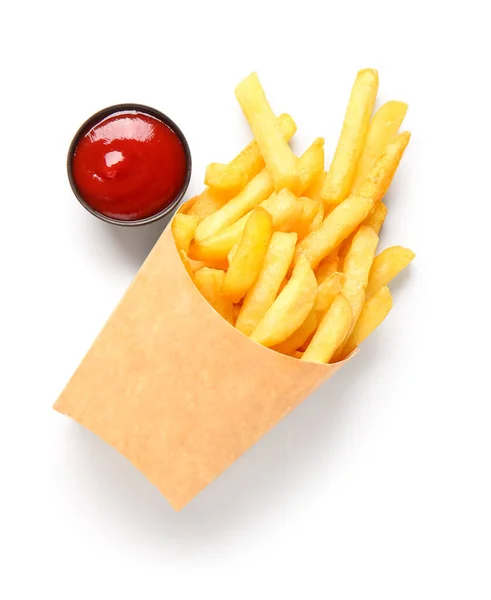 纸盒上有美味的薯条和一碗白色背景的番茄酱 — 图库照片