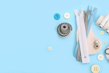 Mavi arka planda terzi malzemesi olan podyumlar