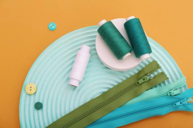 İplik makaralı, fermuarlı ve turuncu arkaplanlı podyumlar