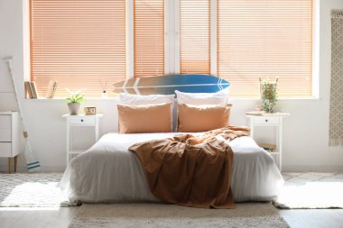 Büyük yataklı, masalı ve pencereli aydınlık yatak odasının içi