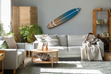 Sörf tahtası ve kanepeleri olan bir oturma odası.