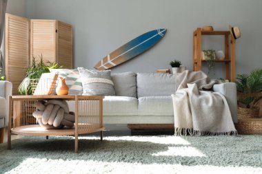 Sörf tahtası ve kanepesi olan bir oturma odası.