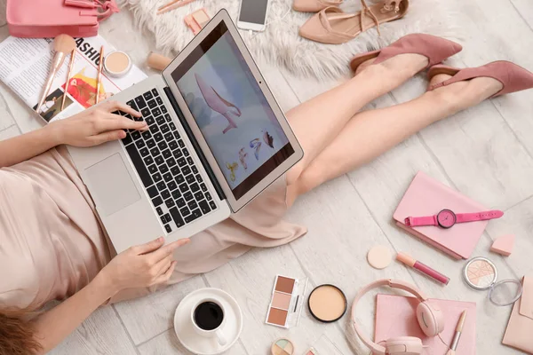 ノートパソコンやアクセサリーを持つ女性光木製の床の上にオンラインショッピング — ストック写真