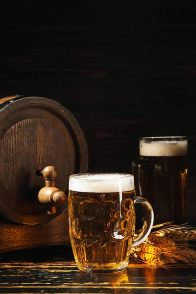 Becher Mit Kaltem Bier Und Holzfass Auf Dunklem Hintergrund — Stockfoto