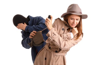 Young woman with pepper spray defending herself against thief on white background