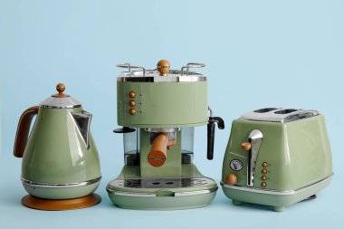 Elektrik ısıtıcısı, kahve makinesi ve mavi arka planda tost makinesi.
