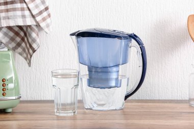 Modern filtre sürahi ve mutfak tezgahında bir bardak su.