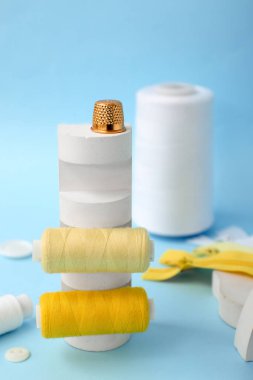 Mavi arkaplanda iplik makaralı podyum, yakın plan