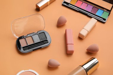 Turuncu arka planda süngerli dekoratif kozmetik ürünler