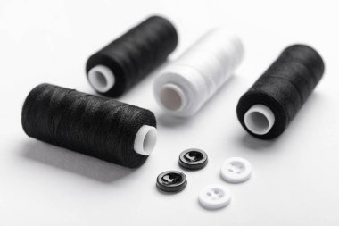 Işık arkaplanındaki iplik makaraları ve düğmeleri