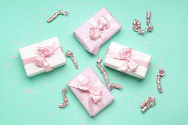 Fiyonklu hediye kutuları, türkuaz arka planda yılan ve konfeti.