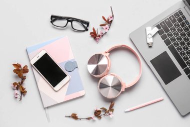 Modern cihazlar, defter ve çiçek açan ağaç dalları olan kompozisyon