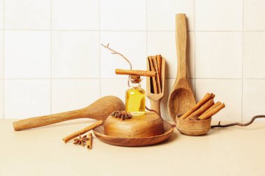 Beyaz fayans duvarının yanındaki masada tarçın, anason, kase ve kaşıklarla gerekli yağ var.
