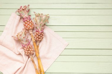 Yeşil ahşap arka planda peçeteli dekoratif ananaslar