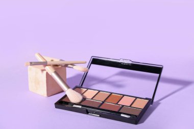 Göz falı paleti, fırçalar ve eflatun arka planda sıva kürsüsü