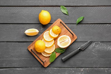 Siyah ahşap arka planda taze limonları olan tahta.