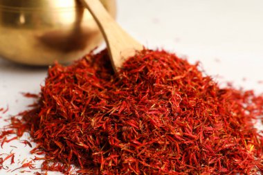 Arkaplanda safran yığını olan kase ve kaşık.