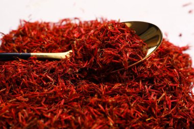 Beyaz arkaplanda safran yığını olan kaşık