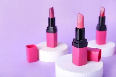 Eflatun arka planda dekoratif alçı podyumlar ve rujlar