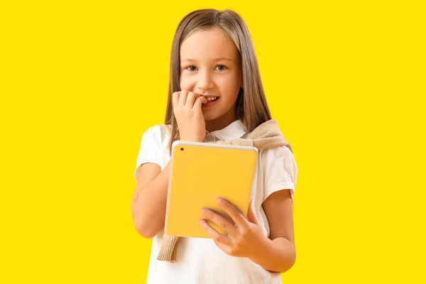 Menina Com Tablet Computador Mordendo Unhas Fundo Amarelo — Fotografia de Stock
