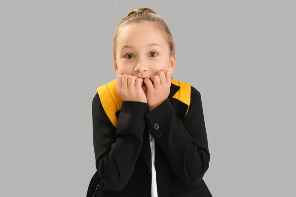 Little Schoolgirl Backpack Biting Nails Grey Background — Fotografie, imagine de stoc
