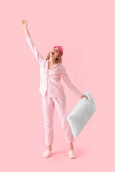 Pembe Arka Planda Yastıklı Pijamalı Mutlu Genç Kadın — Stok fotoğraf