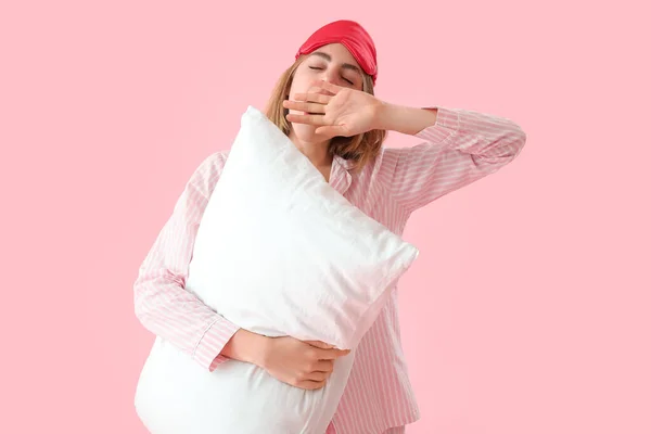 Молодая Женщина Пижаме Подушкой Зевает Розовом Фоне — стоковое фото