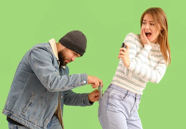 Young Woman Pepper Spray Defending Herself Thief Green Background — Zdjęcie stockowe