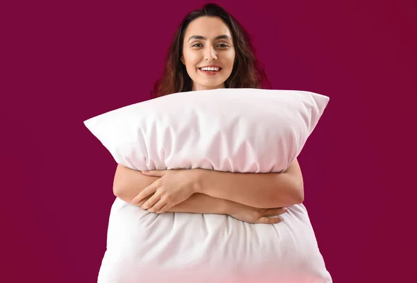 若いですブルネット女性とともに枕上のピンクの背景 — ストック写真