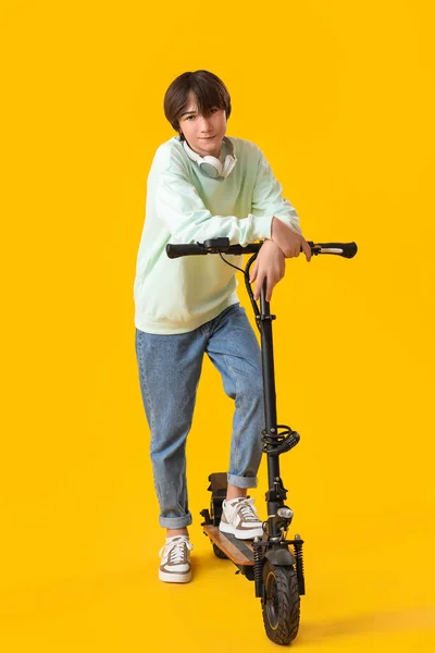Tonårspojke Med Elektrisk Cykel Gul Bakgrund — Stockfoto