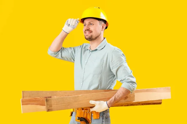 Homem Carpinteiro Com Pranchas Madeira Fundo Amarelo — Fotografia de Stock