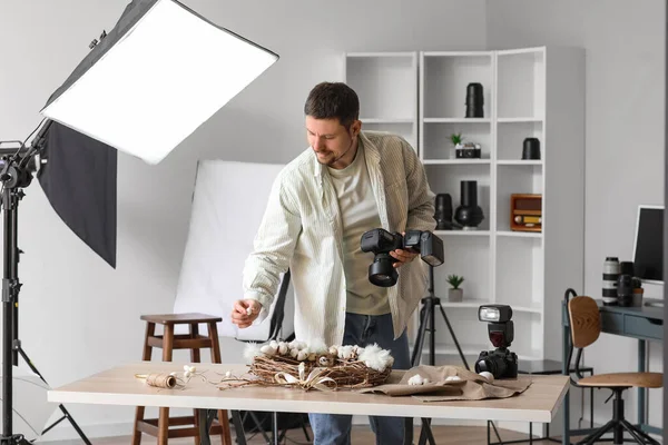 stock image Male photographer taking picture of Easter wreath in studio
