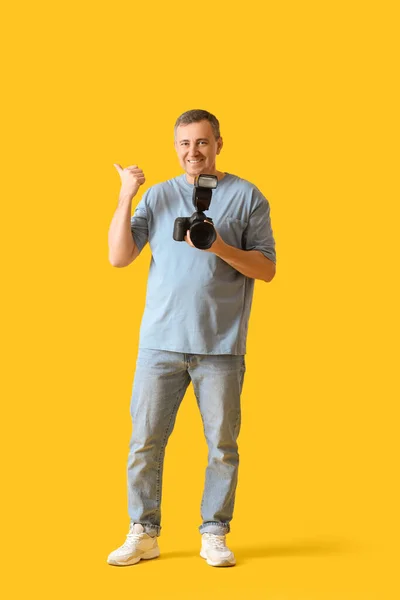 Reifer Fotograf Mit Professioneller Kamera Die Auf Etwas Auf Gelbem — Stockfoto